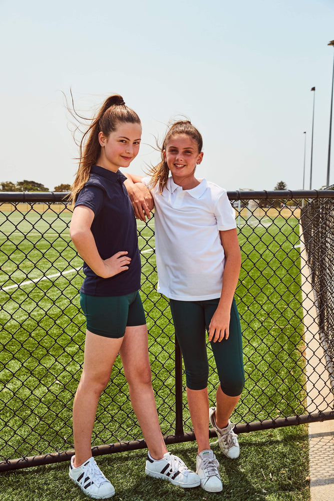 Bottle green bike shorts worn under a school uniform, perfect for layering under skirts, dresses, or sportswear. Customisable forest green and bottle green bike shorts, ideal for school sports teams and personalised activewear.