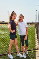 Bottle green bike shorts worn under a school uniform, perfect for layering under skirts, dresses, or sportswear. Customisable forest green and bottle green bike shorts, ideal for school sports teams and personalised activewear.