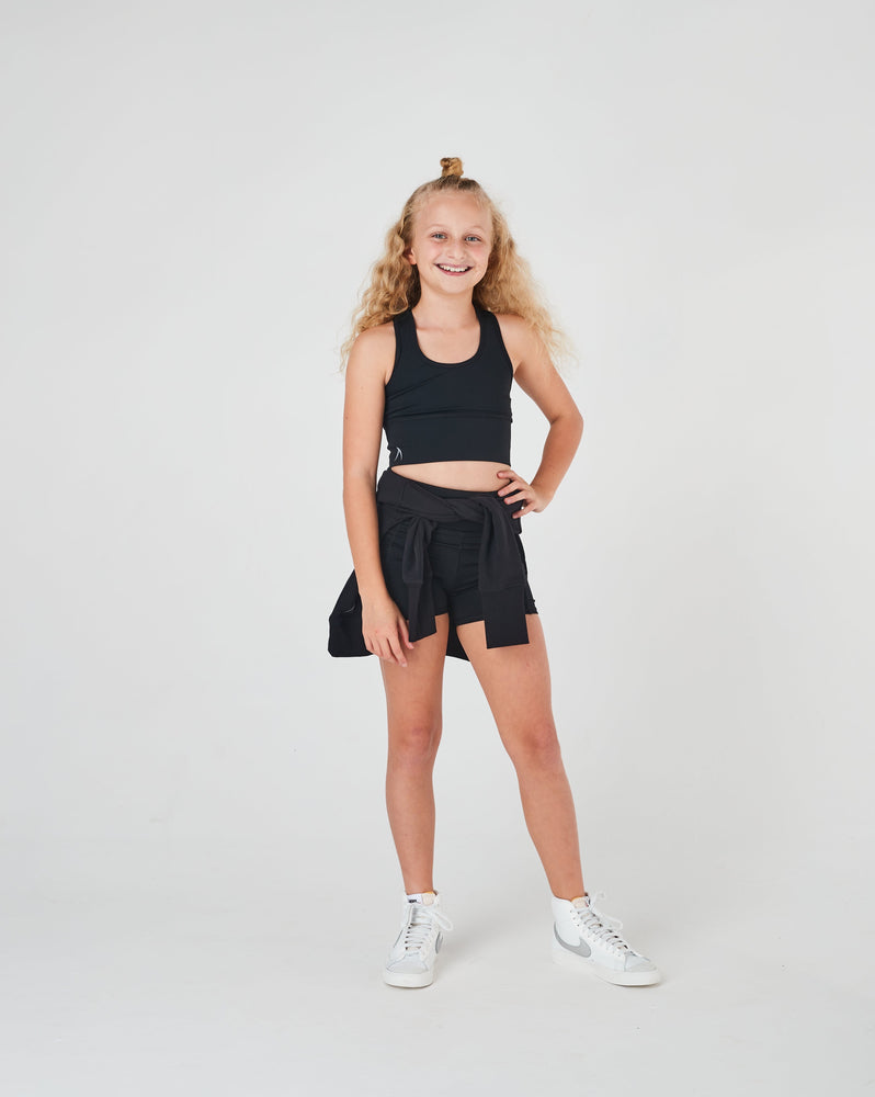 High-performance girls’ netball shorts in black, featuring secure side pockets for carrying small items during training and games.