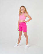 Magenta girls bike shorts in action, perfect for running, cheerleading, and school sports.